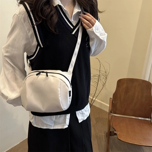 Minimalist white nylon crescent crossbody bag with double zippers and adjustable strap