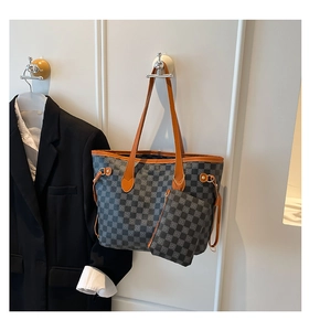 Dettaglio della borsa tote a scacchi con pochette coordinata e manici in pelle marrone