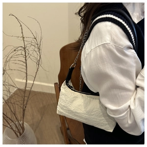 Détail du sac hobo blanc à texture plissée avec une fine bandoulière chaîne