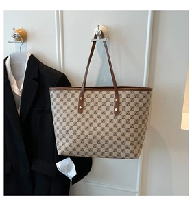 Detail of vintage monogram tote bag with brown leather trim and metal rivets