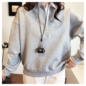Close-up of grey Polo sweatshirt with white collar and circular letter embroidery