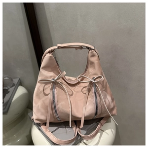 Detail der rosa Schleifen-Schultertasche mit Metallelementen und rauchiger Textur