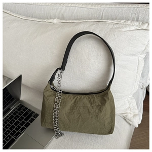 Détail du sac froncé vert olive avec chaîne en métal argenté et bandoulière noire
