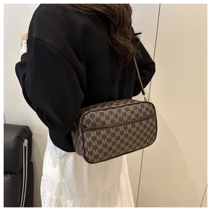 Detailed view of vintage monogram canvas shoulder bag with brown leather trim and side strap