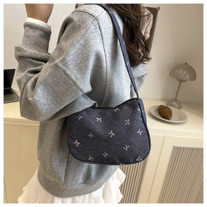 Detailed embroidery of pink and blue bows on the dark blue denim shoulder bag