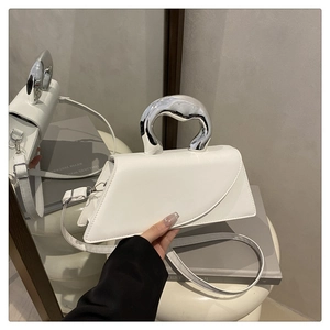 Dettaglio borsa a trapezio in pelle bianca con manico in metallo argento organico