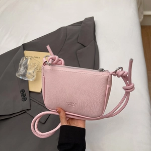 Pink lychee texture crossbody bag with top handle and silver zipper closure