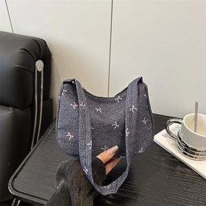 Denim shoulder bag featuring pink and white bow patterns with integrated strap