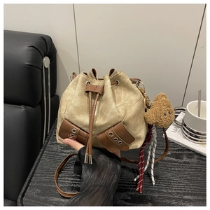 Minimalistische beige canvas bucket bag met bruine bies en een schattige beer hanger