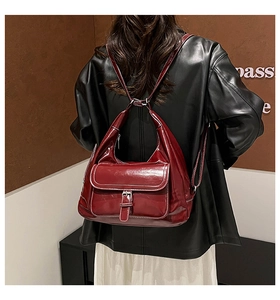 Detail view of burgundy glossy leather tote with elegant white contrast stitching