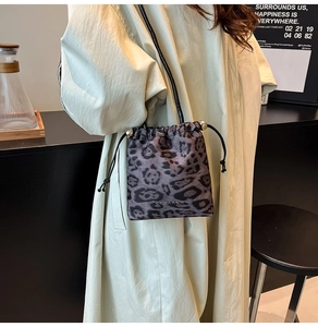 Détail du sac seau léopard avec cordon à billes métalliques et bandoulière en cuir