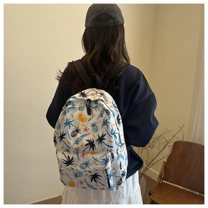 Close-up of tropical print backpack with colorful palm tree and pineapple patterns