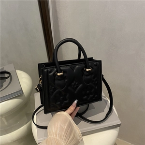 Retro black embossed crossbody bag with floral pattern and gold-tone hardware detail