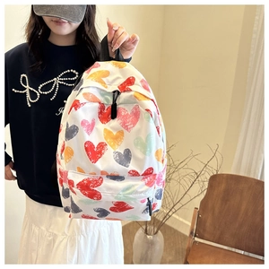 Detail of trendy heart-patterned graffiti backpack with colorful print and front pocket