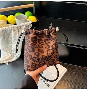 Détail du sac seau léopard avec cordon de serrage, perles métalliques et fine bandoulière