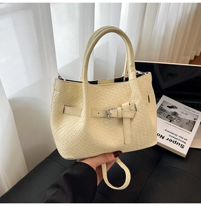 Détail du sac à main beige crème à texture crocodile et boucles de réglage argentées