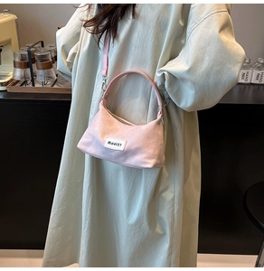Gros plan du sac à main demi-lune en denim rose avec étiquette MJJ137 et détails argentés