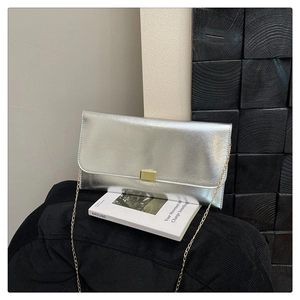 Detailed close-up of a silver textured envelope bag with gold chain strap and metal clasp