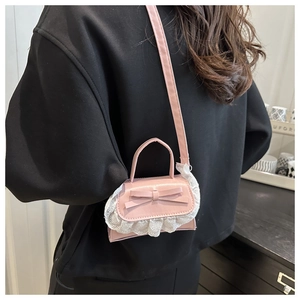 Detailed back view of a pink mini handbag with lace trim and bow knot on model