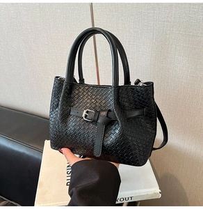 Détail de la texture tressée noire et de la boucle décorative sur ce sac à main