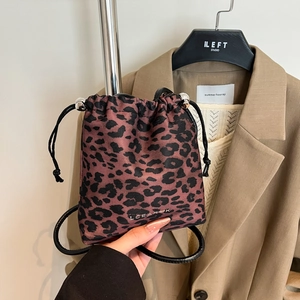 Sac seau léopard tendance avec cordon de serrage et logo argenté dans un décor de mode