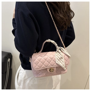 Pink quilted bag with chain strap and elegant silk scarf wrapped around handle detail