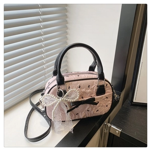Détail du sac Boston rose à motifs de nœuds avec charm en dentelle de perles