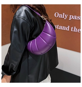 Macro detail of purple crescent shoulder bag featuring horizontal quilted texture