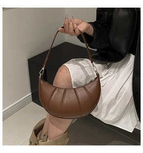 Detailed view of the dark brown crescent bag featuring elegant vertical pleat texture