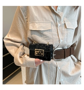 Dettaglio mini borsa nera effetto coccodrillo con chiusura dorata e tracolla a catena