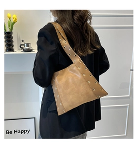 Détail du sac à bandoulière rétro camel avec œillets métalliques argentés et style tendance