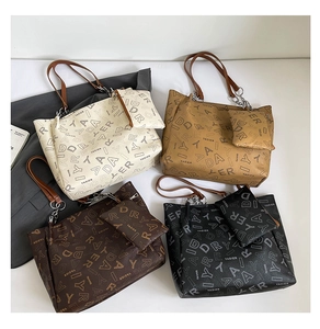 Flat lay of tote bags in four colors with matching mini pouches and letter patterns