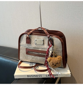 Détail du sac fourre-tout en toile rétro avec bordure en cuir brun et pendentif ours