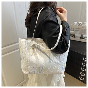 Detail of white tote bag featuring 3D E-letter embossing and wavy color embroidery