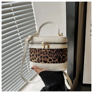 Detail of cylinder bucket bag with leopard print stitching and gold hardware zippers