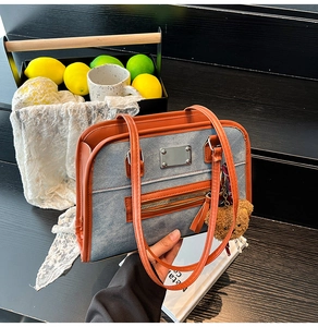 Détail du sac cabas en denim bleu avec finitions cuir et breloque ours en peluche