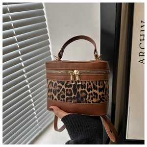 Close-up of leopard print panel and golden zipper on vintage brown bucket bag