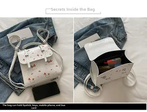 Détail du petit sac à dos en cuir blanc montrant la capacité intérieure pour accessoires