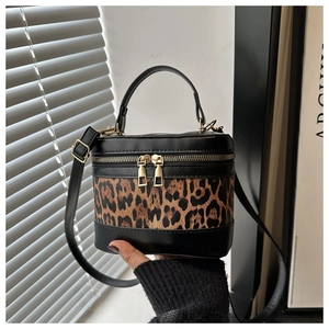 Detail of a mini box bag featuring leopard print panels and gold double zipper closure