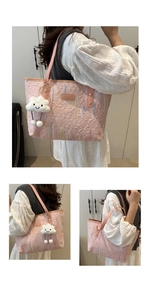Close-up of pink tote bag featuring rainbow wavy embroidery and a plush cloud charm