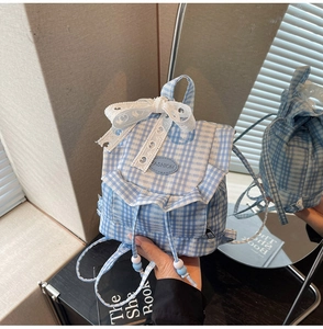 Detail of blue plaid canvas backpack with lace bow and drawstring closure