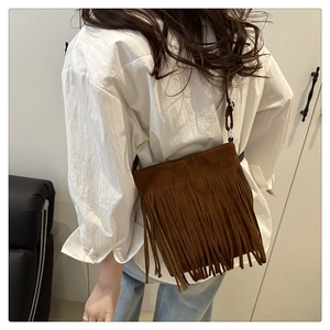 Close-up of deep brown frosted leather tassel bucket bag with elegant long fringe detail