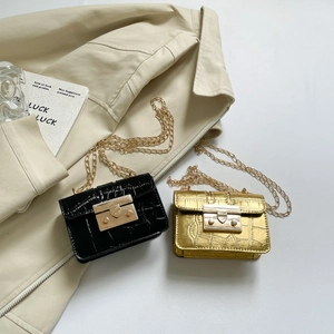 Mini borse a catena con stampa coccodrillo in nero e oro su un trench beige chic