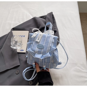 Close-up of blue gingham mini backpack with white lace bow and beaded drawstring detail