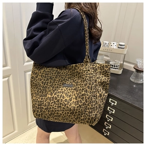 Detailed shoulder view of the large leopard print canvas tote bag on a model