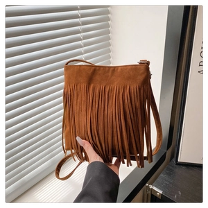 Detailed view of bohemian brown suede crossbody bag featuring stylish long fringe tassels