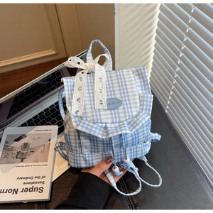 Detailed view of gingham canvas backpack with lace bow and ruffle trim design