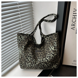 Detail of dark green leopard print tote bag with stitched fashion logo leather patch