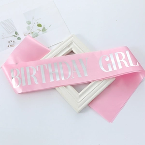 Close-up of pink satin Birthday Girl sash with elegant silver lettering for party