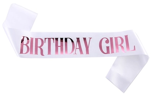 Close-up of white satin Birthday Girl sash with elegant rose gold metallic font